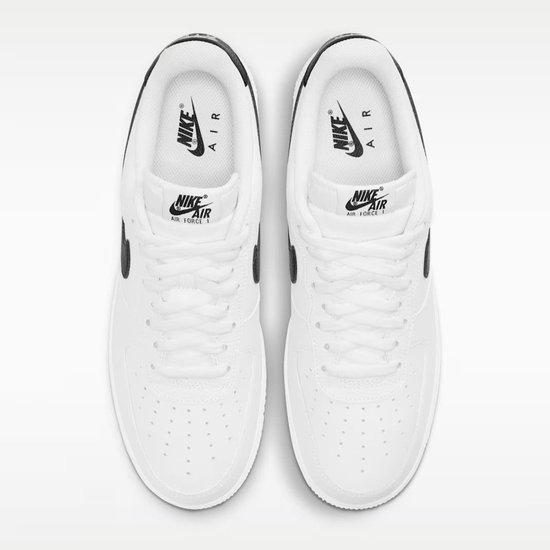 Bovenaanzicht van een paar witte sneakers van generfd leer met zwarte logo's en veters.