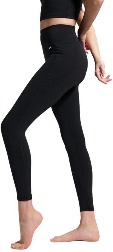 Zwarte, nauwsluitende sportlegging van Under Armour met hoge taille, gedragen door een vrouw, gezien vanaf de zijkant.