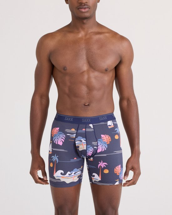 Donkerblauwe boxershorts met een tropische print van palmbomen, boten en golven. De tailleband is donkerblauw met SAXX logo's.