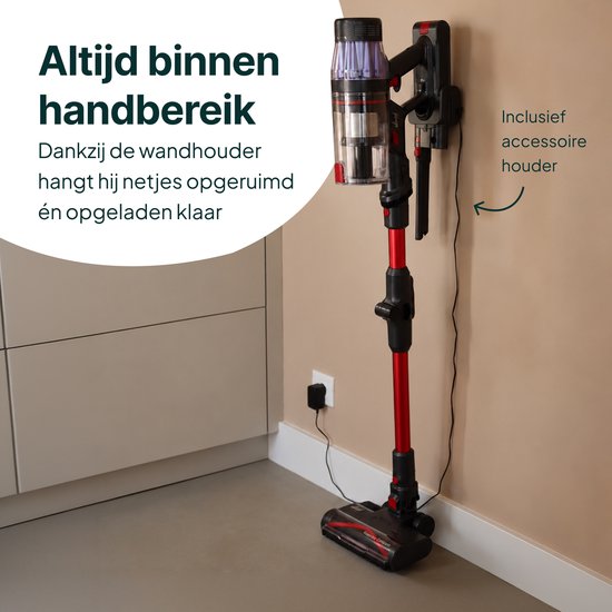 Rode en zwarte steelstofzuiger hangt aan muurbevestiging in een keuken.