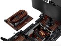 Un bateau pirate LEGO avec un canot brun sur une plateforme séparée.