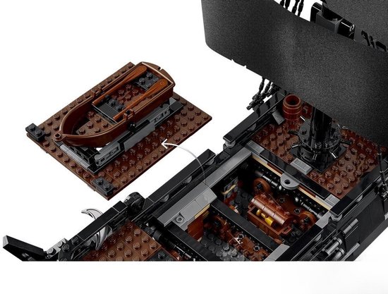 Un bateau pirate LEGO avec un canot brun sur une plateforme séparée.