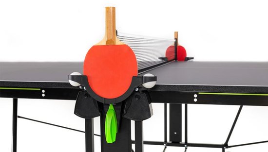 Tafeltennisbatje met rode slagvlakken en houten handvat, rustend op de tafel met net.