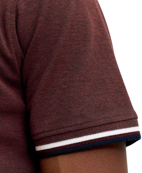 Close-up van de mouw van een donkerrode polo met een textuur en boord.