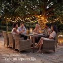 Buiten dineren met een 8-persoons wicker tuinset met glazen tafel en stoelen, verlicht door lichtslingers.