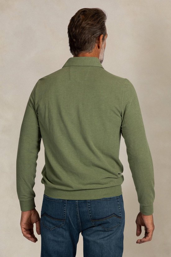 Man van achteren gezien, draagt een lichtgroen poloshirt met lange mouwen en donkerblauwe jeans.