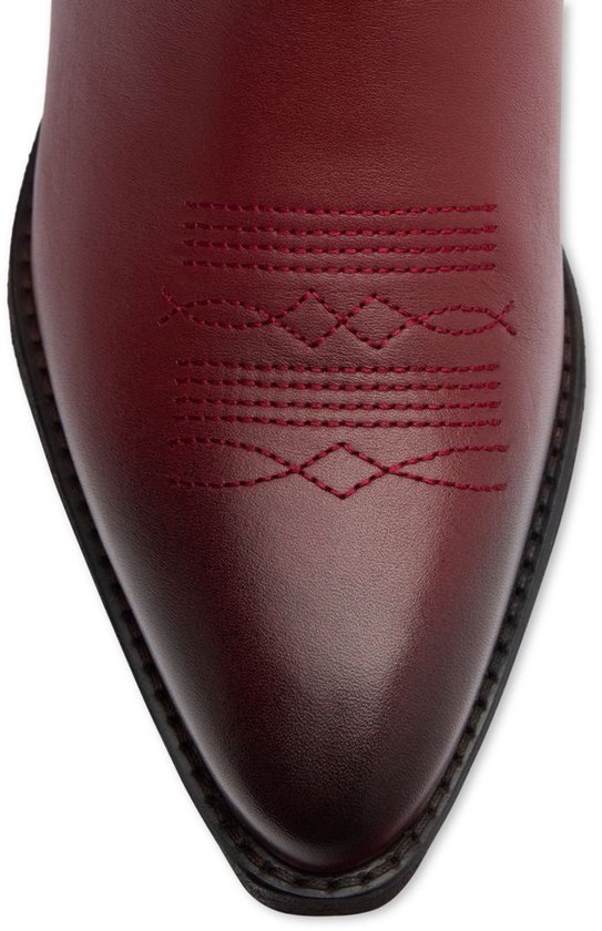 Detail van de neus van een rode cowboylaars met sierstiksels.