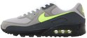 Grijze Nike Air Max 90 sneaker met neon swoosh en 'AIR MAX' op de zijkant.