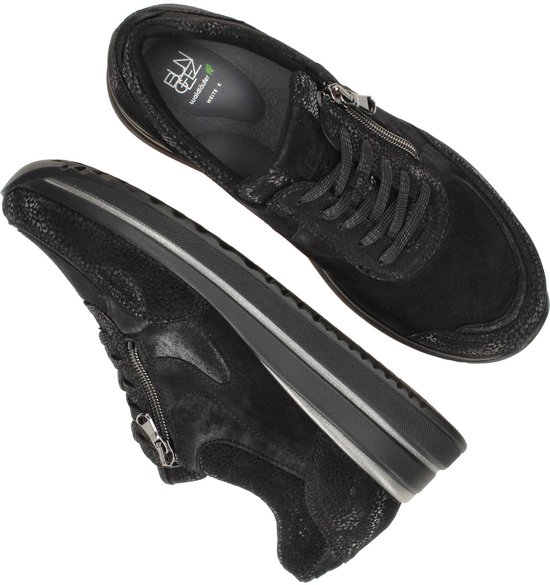 Paar zwarte sneakers met dikke zolen en ritsen, van bovenaf gezien.