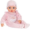 Zittende Annabell babypop in roze velours pakje met schaapprint. Draagt een roze mutsje met "Annabell" erop.