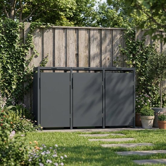 Donkergrijze kliko-ombouw voor 3 vuilnisbakken in een tuin met houten schutting.