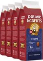 Vier rode pakken Douwe Egberts Decafé koffiebonen op een rij, met focus op de voorste.