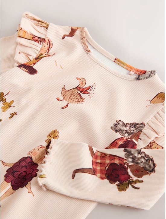 Detail van een crème geribbeld T-shirt met lange mouwen met een print van een eend met sjaal en een meisje.