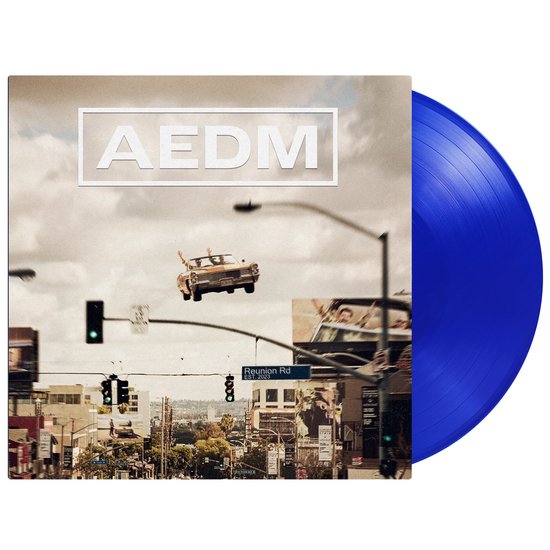 Blauw vinyl album van AEDM, met albumcover van een gele auto die door de lucht vliegt boven een kruispunt.
