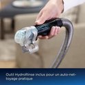Hand houdt de HydroRinse tool vast met water en schuim. "Outil HydroRinse inclus pour un auto-nettoyage pratique"