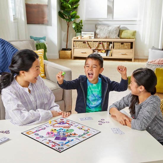 Gezin speelt Monopoly Junior, een bordspel met 2 spellen in 1.