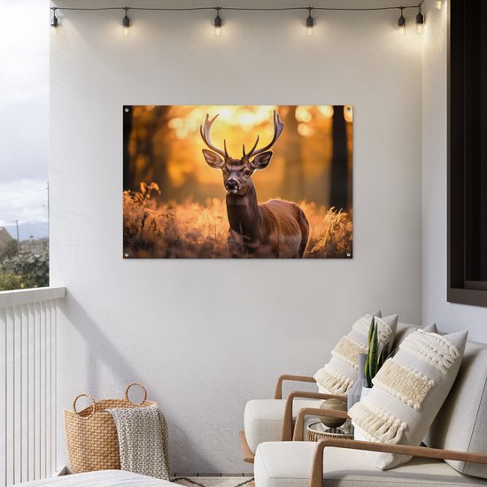 Een tuinposter met een hert en gewei in een bos hangt aan een witte muur op een balkon.