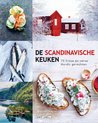 Boek 'De Scandinavische keuken' met afbeeldingen van smörgås met zalm, vissen, een meerlandschap en een rood huis in de sneeuw.