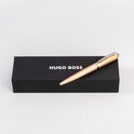 Un stylo bille en bois avec un clip argenté sur une boîte noire HUGO BOSS.