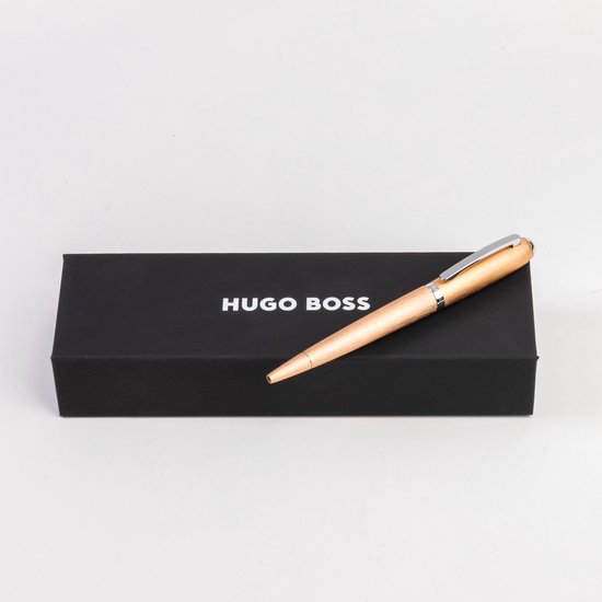 Un stylo bille en bois avec un clip argenté sur une boîte noire HUGO BOSS.