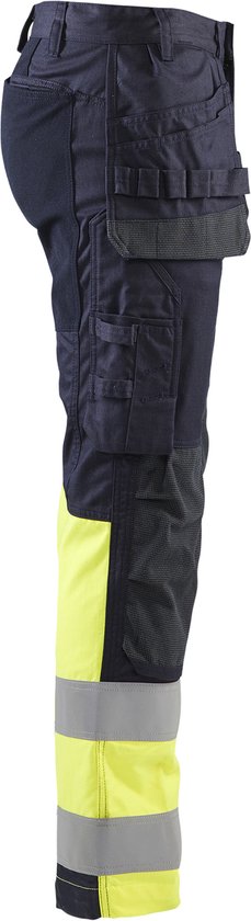 Donkerblauwe werkbroek met gele en grijze reflecterende banden aan de onderkant. Diverse zakken.