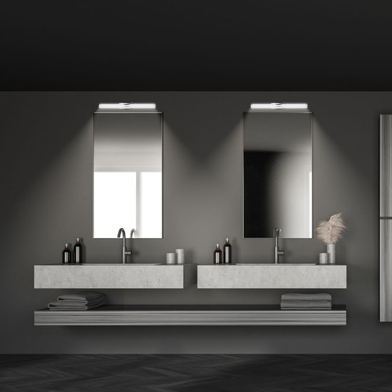 Twee chromen wandlampen gemonteerd boven twee rechthoekige spiegels in een moderne badkamer.
