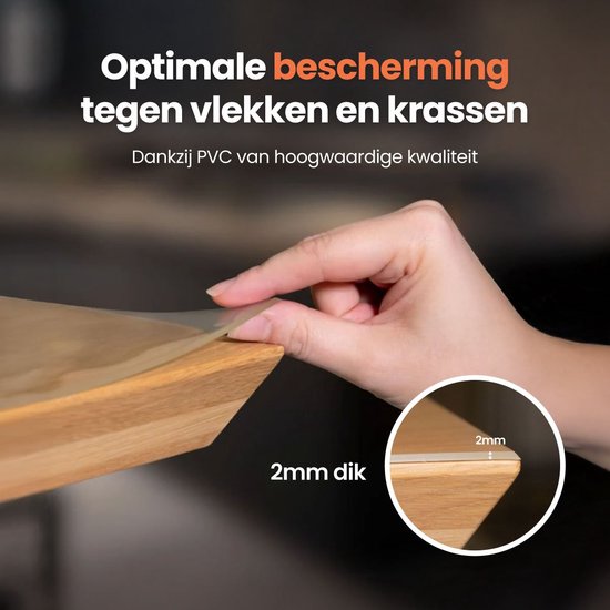 Een hand raakt een 2 mm dik, volledig transparant tafelzeil aan. Het biedt optimale bescherming tegen vlekken en krassen.