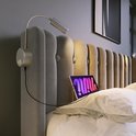 Detail van grijs fluwelen hoofdbord met lampjes, USB-poorten en een tablet.