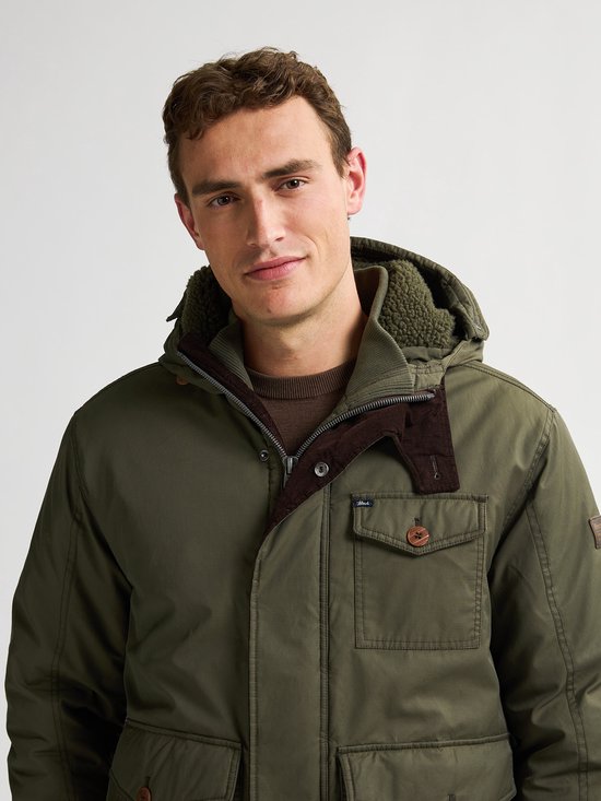 Close-up van groene herenparka met bruine corduroy kraag en houten knoop.