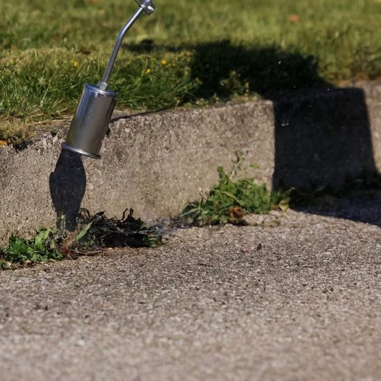 Zilveren brander met metalen kop op gras en beton.