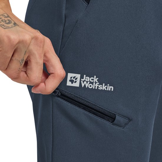Detail van donkerblauwe outdoorbroek met rits en Jack Wolfskin logo.