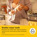 Vrouw in keuken giet moedermelk uit Medela borstkolf in flesje.