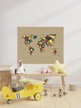 Carte du monde abstraite aux formes géométriques colorées, accrochée dans une chambre d'enfant au-dessus d'un banc en bois avec des jouets.