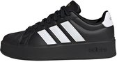 Zijkant van een zwarte damessneaker met platformzool, witte Adidas-strepen en wit hieldetail.