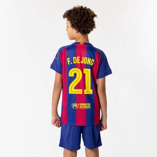 Achterkant van een jongen die een voetbalshirt draagt met de naam F. DE JONG en nummer 21 in geel. Blauwe en rode strepen.