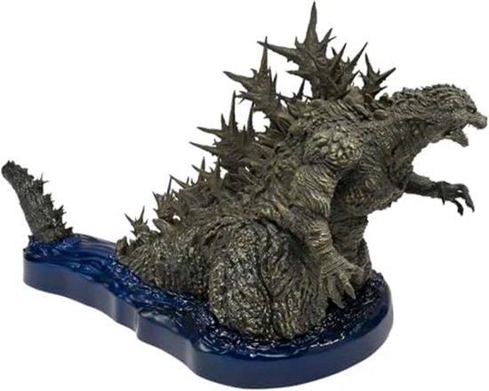 Grijze Godzilla figuur met scherpe rugplaten, op een blauwe waterbasis.