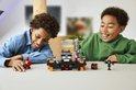 Deux garçons jouent avec un set LEGO Minecraft Wither Battle avec figurines et blocs de construction orange et gris.