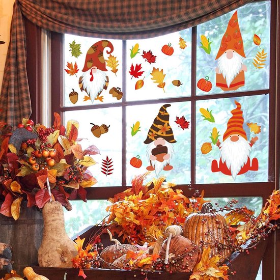 Gnomes d'automne et feuilles d'automne sur une fenêtre, avec des décorations d'automne comme des citrouilles et des feuilles.