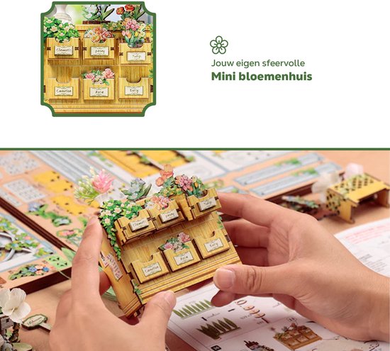 Houten plantenbak met bloemen en handen die het bouwen van een miniatuurhuisje.