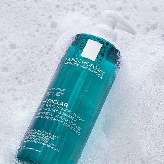 La Roche-Posay Effaclar micro-peeling zuiverende gel in een heldere turkooizen fles met pompje, omringd door schuim.