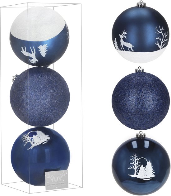 Boules de Noël dans une boîte : deux avec décoration blanche de rennes/arbres et une boule bleue scintillante.