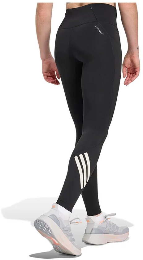 Zicht op de achterkant van een zwarte legging met reflecterende driestrepen op de kuit.