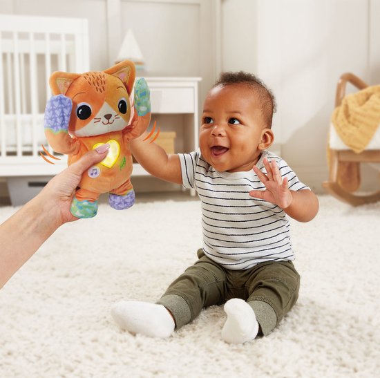 Baby speelt met een oranje VTech Baby Kiekeboe Katje knuffel die hij omhoog houdt.