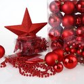 Een rode glitterster, kerstballen en decoratieve kralen in verpakkingen en los.