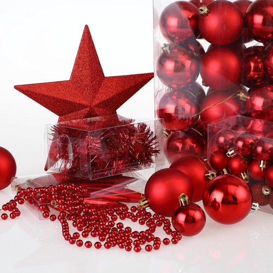 Een rode glitterster, kerstballen en decoratieve kralen in verpakkingen en los.