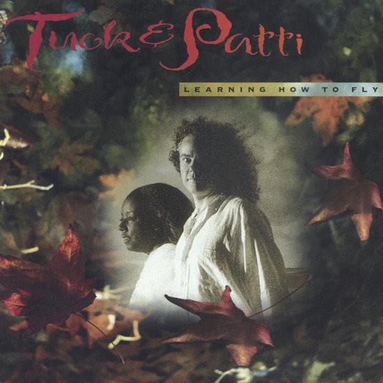 Albumcover 'Learning How To Fly' van Tuck & Patti, met een afbeelding van een man en een vrouw, omringd door bladeren.