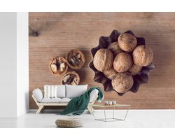 Behang - Fotobehang Bruine walnoten in een kom op een houten lijst - Breedte 450 cm x hoogte 300 cm