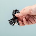 Hand die een opgerolde zwarte USB-kabel vasthoudt.