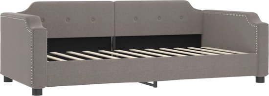 Taupe slaapbank met stoffen bekleding en decoratieve spijkers.