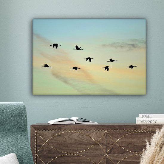 Tableau sur toile Un ciel bleu-jaune avec huit grues - 90x60 cm - Décoration murale